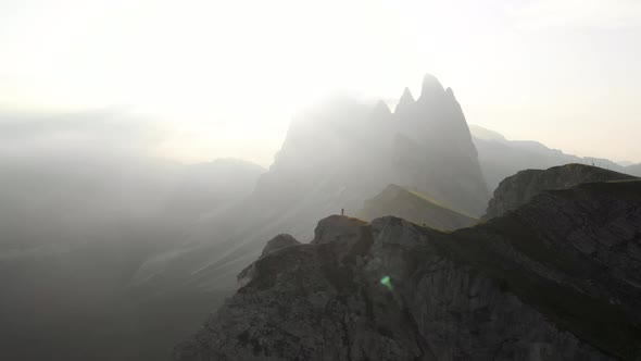 Drone Circle Around Man Hiker Staning on Seceda peak, Dolomites Italy