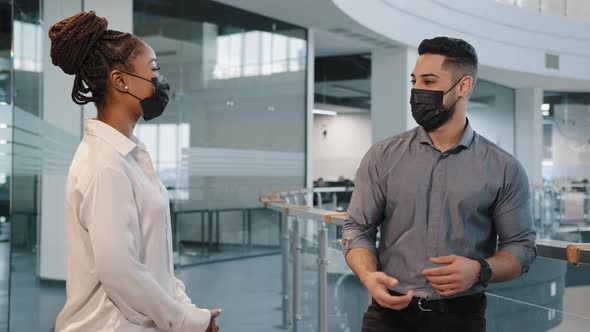 Indian Businessman and African Businesswoman Wear Medical Face Masks Greeting with Elbow Bump in