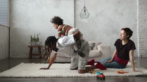 Mixed Race Child Riding on Father's Back at Home