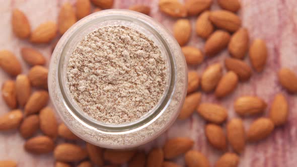 Almond Powder and Almond in a Jar on Table