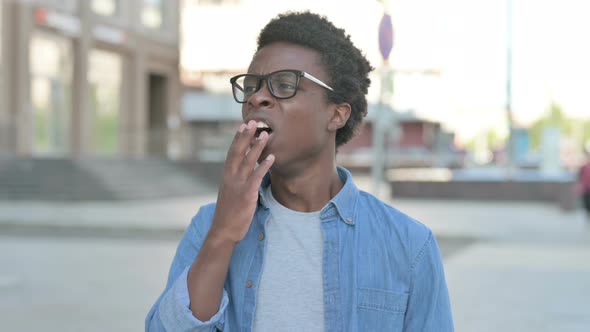 Sleepy Young African Man Yawning Outdoor