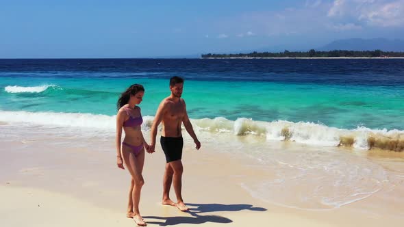 Guy and girl tanning on relaxing seashore beach vacation by transparent sea with clean sand backgrou