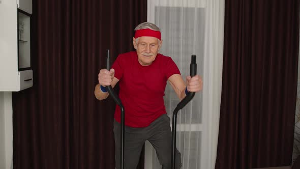 Senior Man in Sportswear Using Orbitrek in Living Room Doing Sport Training Cardio Exercises at Home