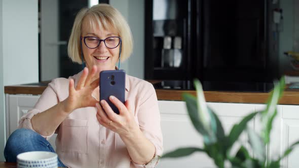 Front view of smiling senior woman scrolling on the phone. Shot with RED helium camera in 8K.