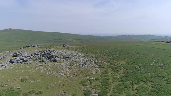 Wide shot aerial tracking forward over Bonehill Rocks, Dartmoor, Devon, England.