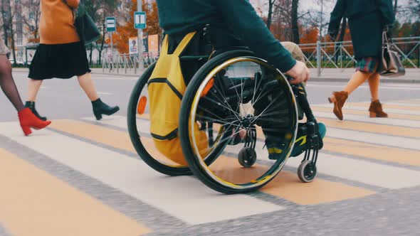 Disabled Man in Wheelchair Crossing the Road with a Bunch of Another People