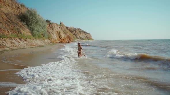 Slow Motion of Happy Joyful Woman with Perfect Slim Fitness Body Wearing in Bikini and Enjoying Wind