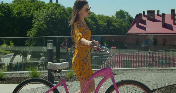 Young Beautiful Woman Riding a Bicycle at Sunset. Cyclist Woman Have Fun.