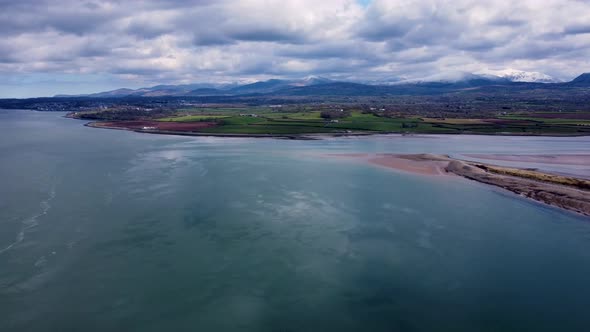 Drone footage looking over the Menai Straits in north Wales towards the Snowdonia mountain range, No