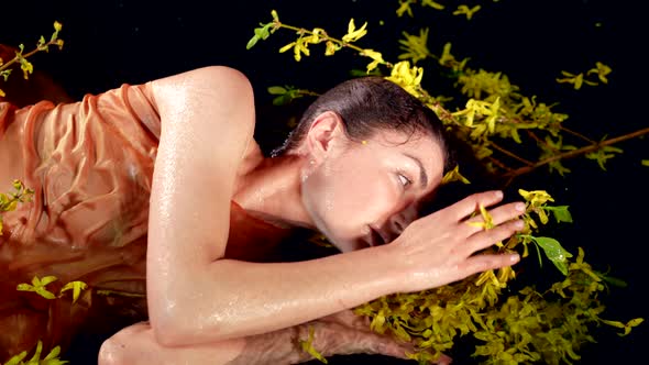 Portrait of Charming Water Nymph in Shallow of Magical River or Lake Woman is Playing with Flowers