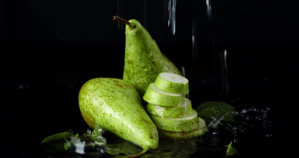 Slices and Whole Pears with Leaves Under the Water Drops. 