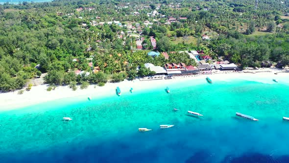 Idyllic exotic beach with white sand surrounded by azure lagoon full of anchored boats waiting for t