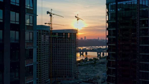 Aerial Horizontal Flight Over Construction Site in City at Sunset