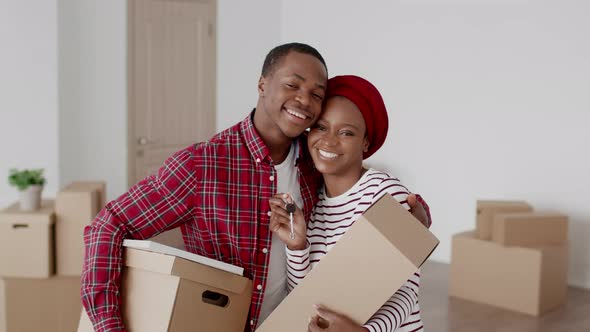 Black Couple Holding New House Key And Moving Boxes Indoor