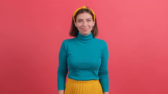 Pretty Girl Looking at Camera with a Smile, Isolated Over Red Background.