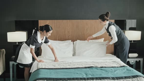 Hotel Employees Making Bed in Room
