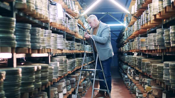 Archive Specialist is Looking for a Film Case on the Shelves