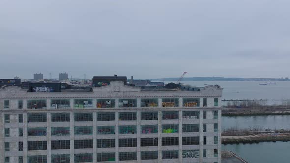 Forwards Fly Above Old Factory Buildings on Waterfront Abandoned and Decorated with Graffiti Images