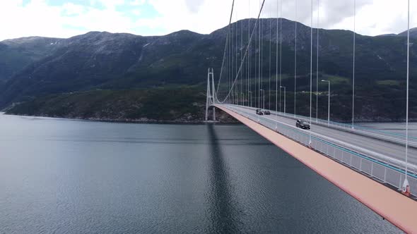 Hardanger bridge - Forwarding aerial close to massive suspension bridge over fjord - Looking ahead w