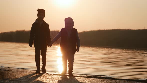 Brother and Sister Are Having Fun By the River at Sunset.