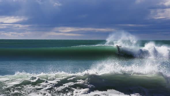 surfer performs a re-entry on a wave at a point break near kaikoura