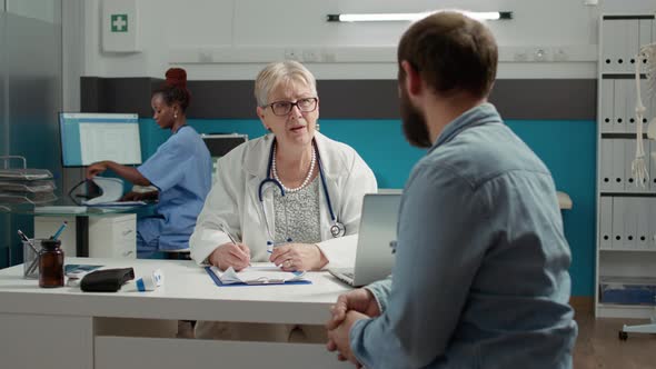 Physician and Man Having Conversation About Health Care at Appointment