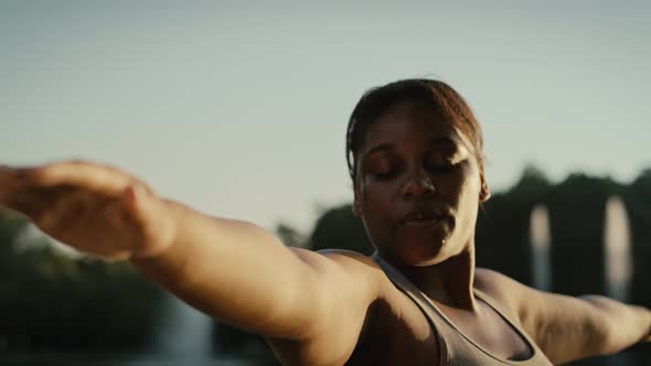 African American woman practicing yoga exercise at the park. Shot with RED helium camera in 8K.