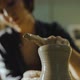 Young Female Potter Gently Pulls the Walls of a Clay Vessel on a Potter's Wheel - VideoHive Item for Sale