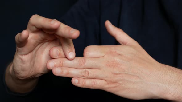 Man is doing a trick with hands, close up. Disappearing finger