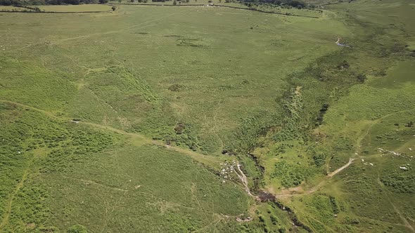 Aerial push over a green valley in Dartmoor National Park, United Kingdom