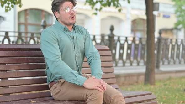 Man having Knee Pain while Sitting on Bench