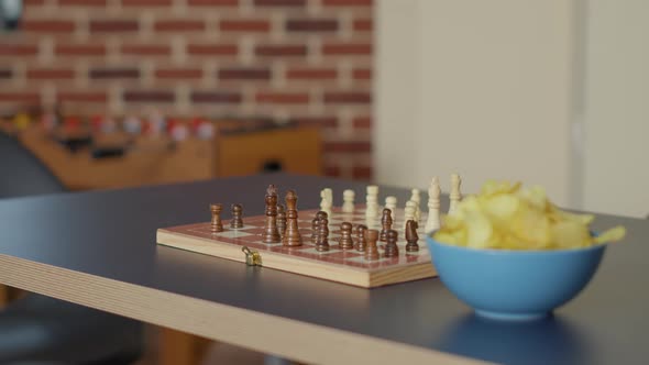 Empty Living Room Table with Chess Board Game and Bowl of Chips