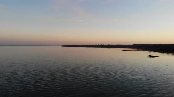 Aerial view flying across the sea in Nykøbing Bugt with swimming and flying seabirds in a beautiful