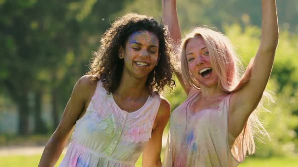 Beautiful Female Friends Covered in Colorful Paint Hugging, Smiling to Camera