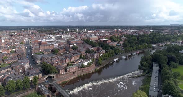 Aerial track shot of the River Dee above a weir in Chester, England