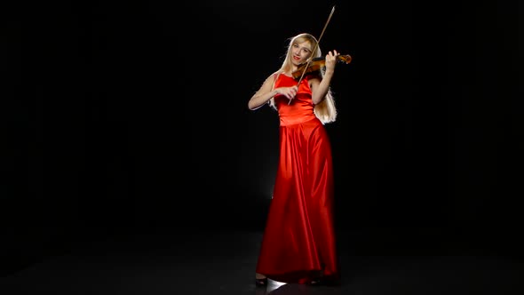 Woman Plays the Fiddle. Studio. Black Background