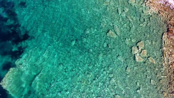 Clear and Shallow Sea Water of the Cove Surrounded by Stone and Rocky Coastline