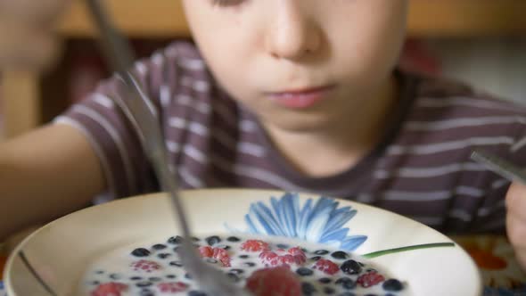 Young Boy in Striped Tshirt Eats Fresh Delicious Berries