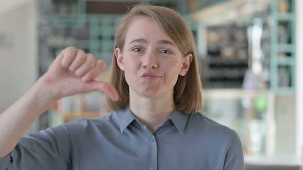 Thumbs Down Gesture By Young Woman