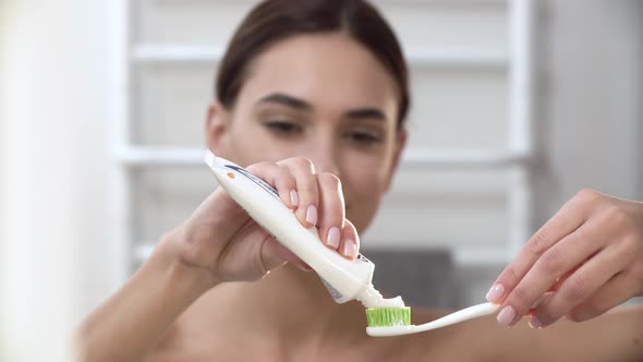 Teeth Hygiene. Woman Applying Toothpaste On Toothbrush Closeup