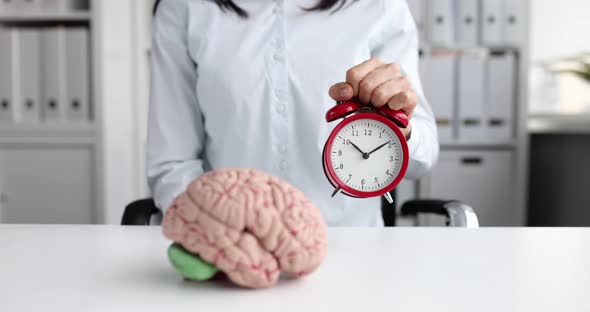 Head Puts Red Alarm Clock with Brain Layout