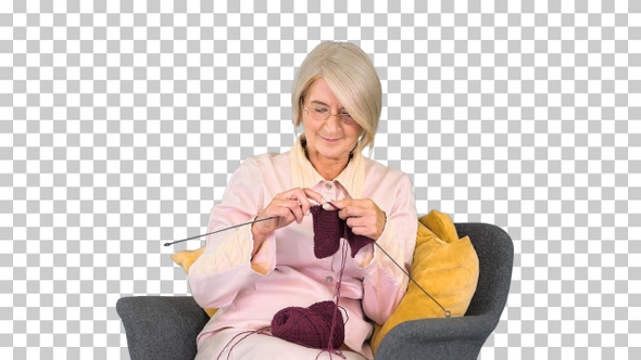 Elderly woman knitting woolen clothes, Alpha Channel