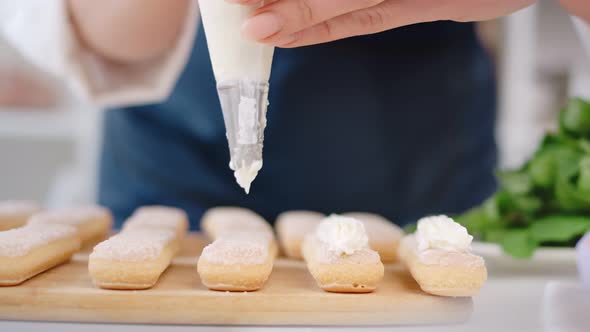 Female Confectioner Hands Applying Whipped Cream From Pastry Bag