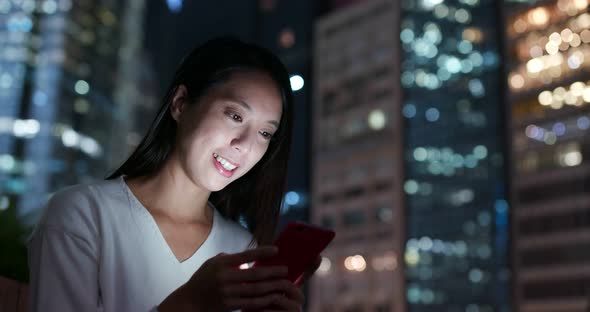 Woman use of mobile phone in city over building background