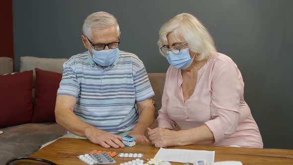 Senior Couple Grandfather and Grandmother Monitoring Oxygen Saturation with Digital Pulse Oximeter