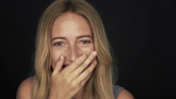 Young woman laughing and covering mouth