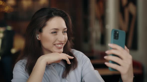 Cheerful Woman Using Mobile for Taking Selfie at Cafe