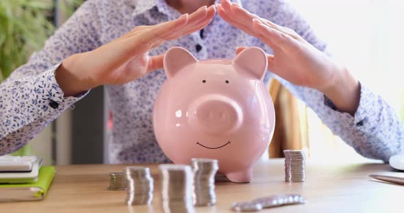 Insurance Agent Woman Holds Hands on Piggy Bank