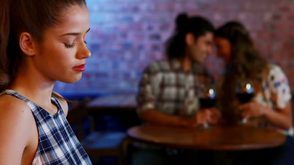 Jealous woman looking at couple flirting with each other