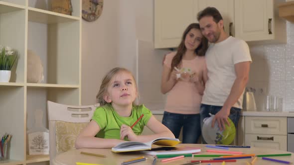 Happy Parents Proudly Watching Their Smart Daughter Doing Homework, Family